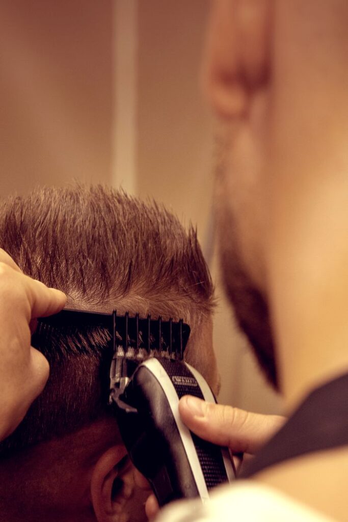 Close-up image of a barber using an electric trimmer for a modern male haircut.